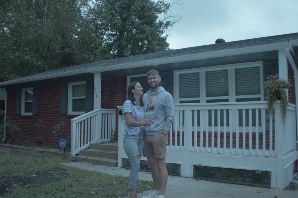 Happy couple in front of their third acre home